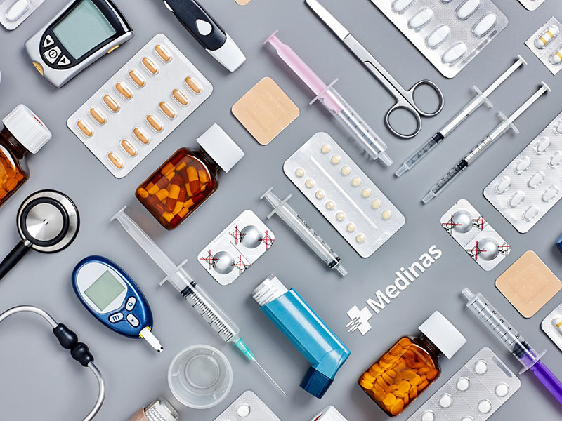 Directly above flat lay flat lay shot of various medical supplies. Full frame shot of medicines placed with syringes and diagnostic tools. All are on gray background.  Knolling concept.